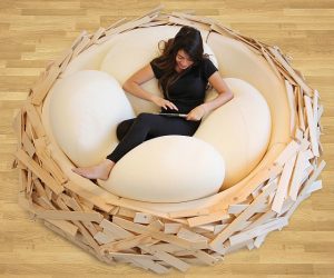 Women laying in a wooden bed shaped like a birds nest