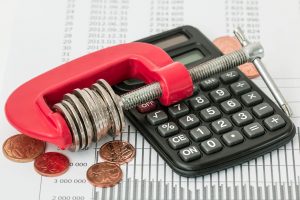 black calculator and cents in side a red clamp