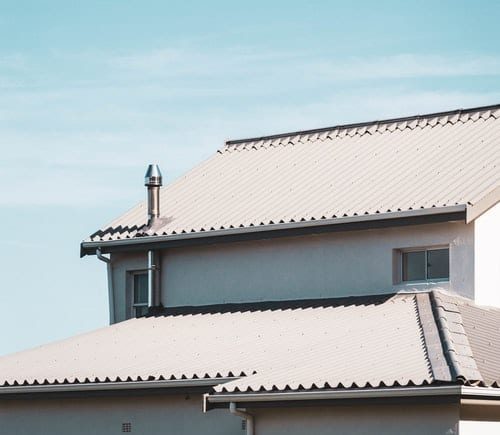 grey roof among a blue sky with some wispy clouds