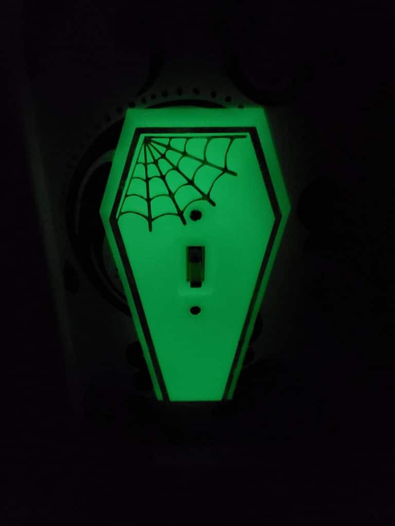 glow in the dark coffin-shaped light switch with spider web