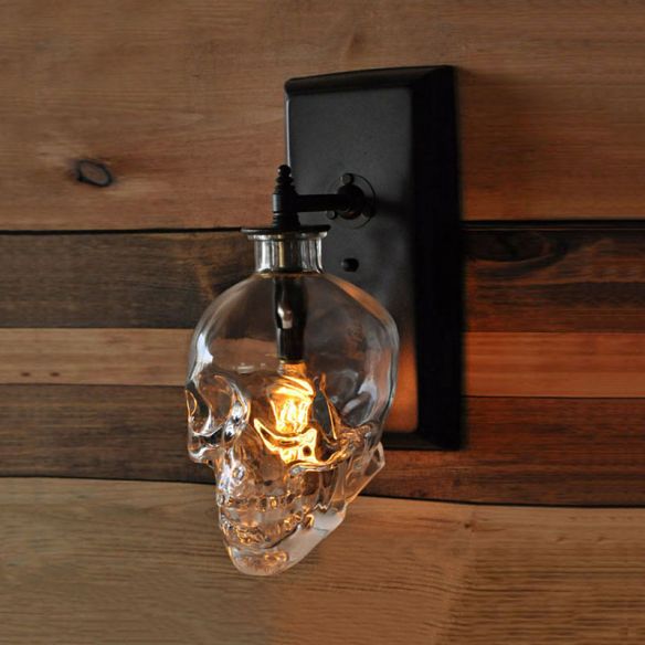 clear skull shaped glass over a lightbulb on the wall