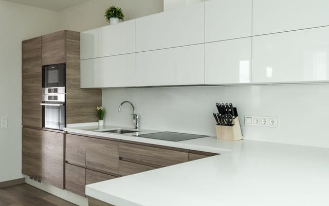 modern updated kitchen with white simple cabinets and wood features