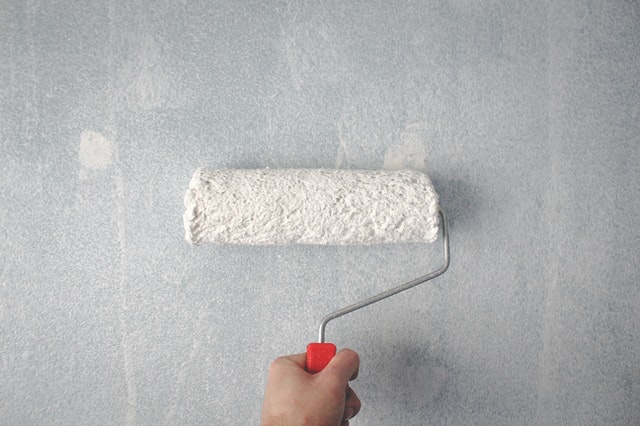 paint roller with white paint on a kitchen wall