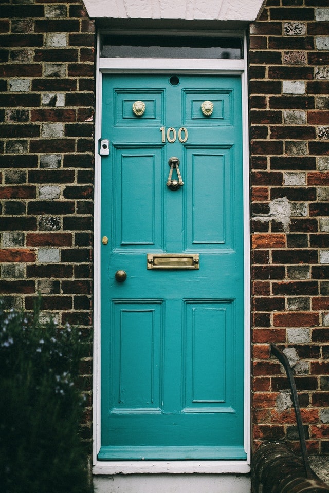 tuqoise door with knocker and mail slot